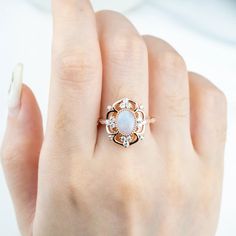 The "Ophelia" ring is an opulent masterpiece, featuring an oval-cut natural opal as its centerpiece, set in 18k rose gold. The intricate design surrounds the luminous opal with sparkling moissanite stones, creating a radiant floral motif. This vintage-inspired yet statement-making ring exudes both elegance and drama, perfect for those seeking a bold yet sophisticated look. "Ophelia" captures the ethereal beauty of nature and the allure of timeless luxury. Flora Ring Design - October Birthstone Ring MAIN STONE Stone: Natural Opal Shape: Oval Cut Color: blue white Measurements: 5x7mm SIDE STONES Moissanite:Round Cut:1.5mm--4 2.0mm--2 2.5mm--2 Marquise Cut:2.0*4.0mm--2 BAND Style: Cluster / Flora Ring / Vintage Ring Material:14k Gold: yellow, white, rose18k Gold: yellow, white, roseOther Meta Rings Opal Engagement, Unique Vintage Rings, Opal Gold Ring, Rings Opal, Unique Rings Vintage, October Birthstone Rings, Opal Engagement Ring, Rutilated Quartz Ring, Opal Ring Gold