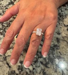 a woman's hand with a diamond ring on it