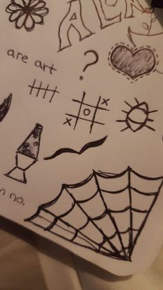 a drawing on paper with some writing and symbols drawn on it's surface, including a spider web