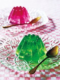 two glass dessert dishes with spoons on a checkered tableclothed table cloth