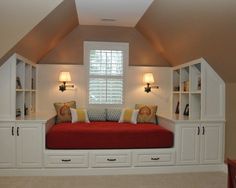 a room with some white cabinets and red couches in it's center area