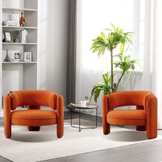 two orange chairs sitting next to each other in front of a window