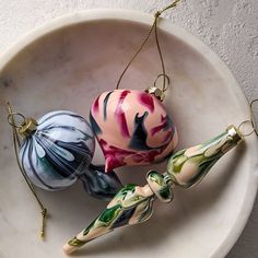 three blown glass ornaments in a bowl