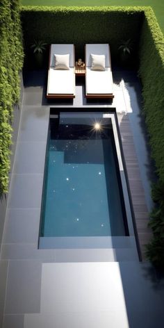 an aerial view of a pool and lounge chairs in the middle of a garden area