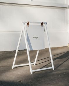 an open sign stands in front of a white building