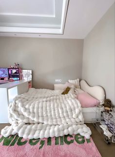 a room with a bed, desk and television on the wall next to each other