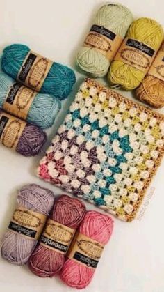 several balls of yarn sitting next to each other on top of a white tablecloth