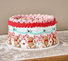 a decorated cake with gingerbreads and candy canes on the top is sitting on a table