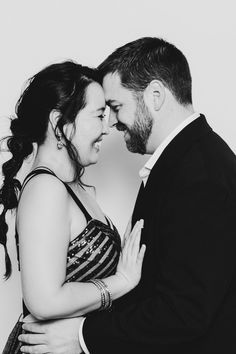 black and white photograph of a man and woman embracing each other in front of a wall