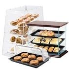 three tiered display case with donuts and other pastries in front of it