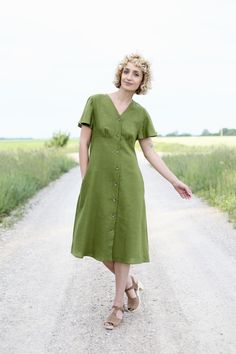 "Linen dress in moss green color. Short frill sleeves, button placket through. V neckline and side seam pockets. - Handmade in our studio from 100% organic linen - A - line silhouette - V neckline - Tortoise shell buttons closure - Side seam pockets - Below the knee length FABRIC&CARE Available in any other color of listed linen. The linen fabric is medium weight and 100 % Oeko-Tex certified, which means that it meets ecological requirements. Hand wash or gently machine washable 30oC, hang d Green V-neck Dress With Pockets, Khaki V-neck Dress With Pockets, Green Linen V-neck Dress, Green Linen Short Sleeve Dress, Green Linen Dress With Buttons, Green V-neck Linen Dress, Spring Green Linen Dress With Pockets, Green Linen Dress With Pockets For Spring, Spring Olive Linen Dress