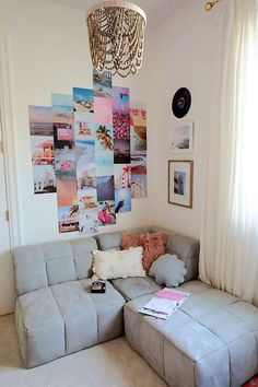 a living room with a gray couch and pictures on the wall above it, along with a chandelier