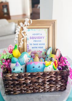 a basket filled with toys sitting on top of a table next to a framed sign