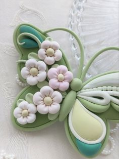 a close up of a butterfly with flowers on it's back and wings in pastel colors