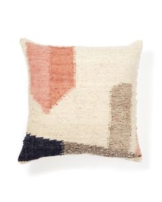 an orange, black and white pillow on a white background