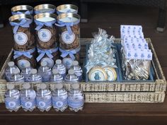 baby shower items displayed on wooden trays with blue ribbon and tags in glass jars