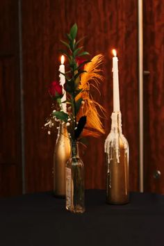 two vases with flowers and candles on a table