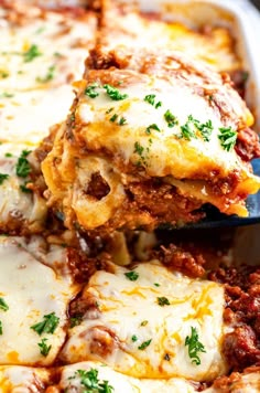 a spoon full of lasagna casserole being lifted from the casserole dish