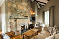 a living room filled with furniture and a fire place next to a wall mounted tv