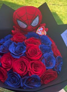 a bouquet of red, white and blue roses with a spiderman mask on top