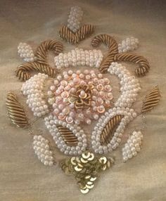 some pearls and gold brooches on a white cloth