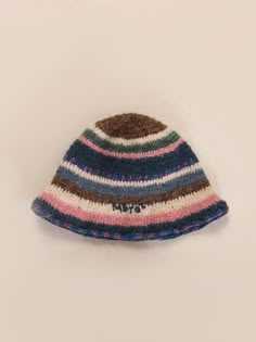 a multicolored knitted hat is displayed on a white surface, with the word natt written across it