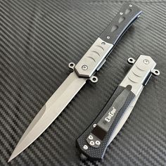 two knives sitting on top of a table next to each other with black handles and blades