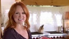 a woman holding a piece of meat in a kitchen