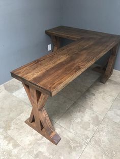 a wooden bench sitting on top of a tile floor next to a blue painted wall