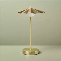 an umbrella lamp on a table with a green wall in the background