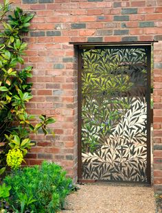 an open door to a brick building with green plants