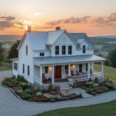 a large white house with a red front door and two porches on top of it