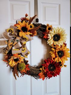 a wreath with sunflowers and burlocks is hanging on the front door