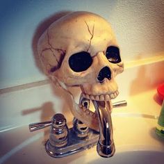 a sink with a skull shaped faucet and soap dispenser