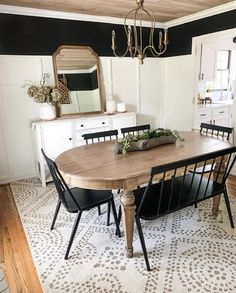 a dining room table with four chairs and a chandelier hanging from the ceiling