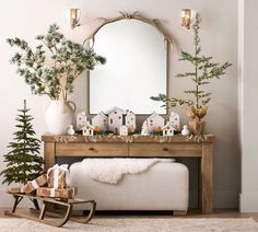 a living room decorated for christmas with trees and decorations on the mantle, mirror and bench