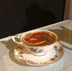 a cup filled with blood orange slices on top of a saucer and saucer