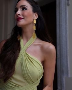 a beautiful woman in a green dress posing for the camera