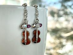 These dainty and cute violin earrings are perfect for musical concerts and gifts for violinists, friends and musicians.  They are made of the following: (1) Gold or silver plated brown enamel violin charm (charm size: 23 x 8 mm) (2) Gold or silver plated earring ball studs with titanium stand and catch  (3) Swarovski crystals:  Style A - red / yellow / purple  Style B - silver knight / purple / clear AB 💕 NECKLACE 💕 GOLD → https://www.etsy.com/listing/782737992 SILVER → https://www.etsy.com/listing/263673497 【ADDITIONAL QUANTITY】 Kindly convo us if you require additional quantity and we will be happy to customize the order to meet your needs. 【BEFORE PURCHASE, PLEASE NOTE THE FOLLOWINGS】 ☆ VAT, GST and any other taxes from your country are NOT included in the listing price. Buyers are re Silver Knight, Music Teacher Gifts, Music Jewelry, Purple Fashion, Violin, Silver Gold, Silver Plate, Swarovski Crystals, Gold Earrings