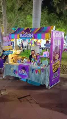 an ice cream stand on the side of the road with people standing around it at night