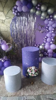 there is a purple cake and balloons on the table