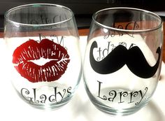 two wine glasses decorated with lipstick and mustaches