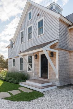 a house with a large front porch and steps leading up to the entry door that leads into the back yard