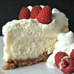 a piece of cheesecake with raspberries on top and whipped cream in the middle