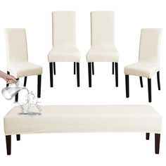 a set of four white chairs and a footstool