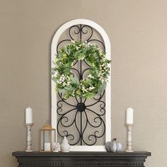 a fireplace with a wreath and candles on it