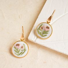 Inspired by the cool and muted colors of winter, this pair of charming hand embroidered floral earrings evoke a sense of calm and stillness. Lightweight and comfortable, they are perfect for everyday wear or special occasions. They also make thoughtful gifts for the special people in your life or for yourself.  These earrings are proudly handmade in the Philippines.  - - - - - - - - - - - - - - - - - - - - - - - - - - - - - - - - - - - - - - - - - - -  DETAILS: * This listing is for a pair of ea Hand Embroidered Jewelry, Embroidery Earrings, Embroidered Earrings, Schmuck Gold, Embroidered Jewelry, Dangling Earrings, Bridal Party Gifts, Special People, Floral Earrings