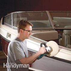 a man is painting a boat with white paint