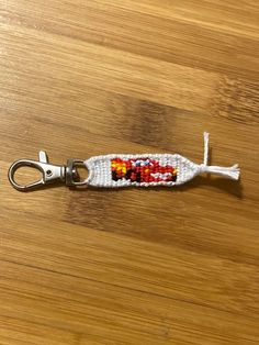 a keychain made out of beads on top of a wooden table