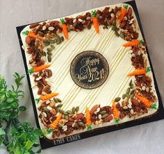 a birthday cake with carrots, nuts and leaves around it that says happy new year